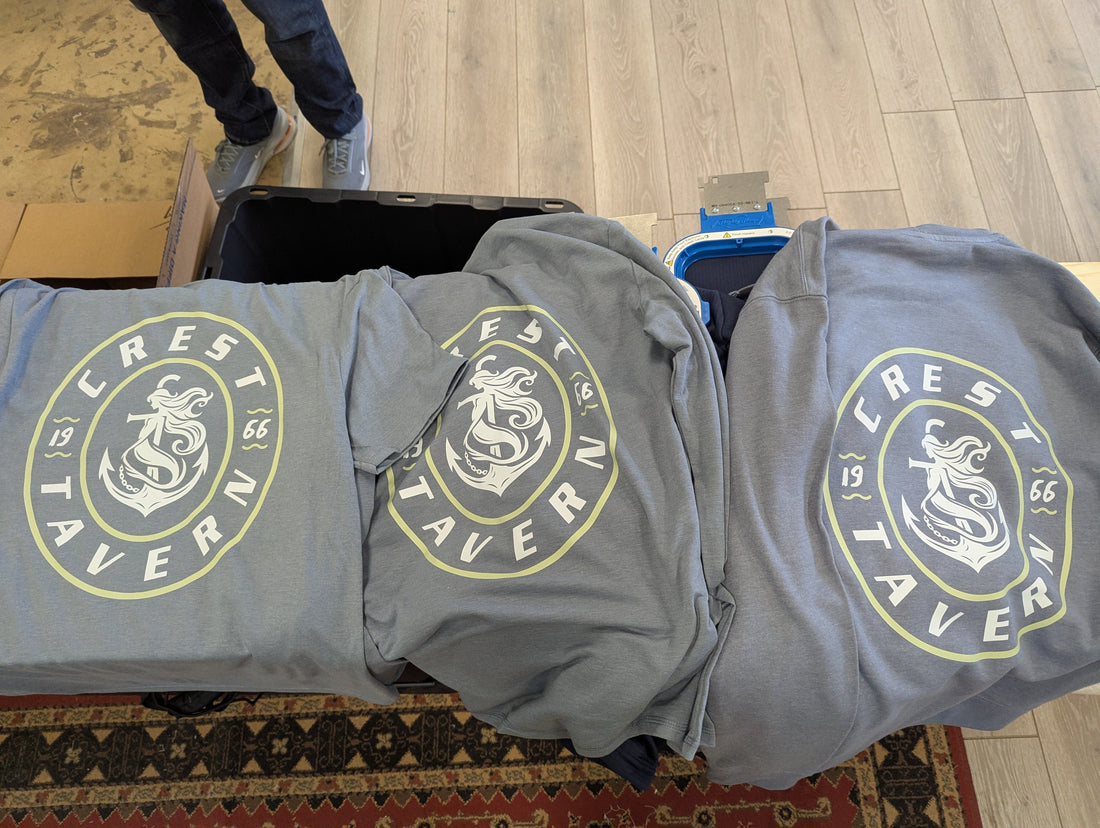 A Picture of three light blue shirts with a dtf transfer print on them